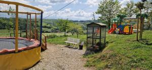 a park with a playground with a bench and play equipment at Camping Le Bourdieu in Durfort