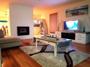 a living room with a coffee table and a tv at Paradise by the Bay in Callala Bay
