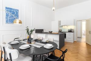 a kitchen and dining room with a table and chairs at Lavish city center suites near National Theatre by Prague Days in Prague