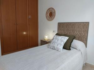 1 dormitorio con 1 cama y armario de madera en Vistas al mar en Canet Playa WIFI, en Canet de Berenguer