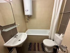 uma casa de banho com um lavatório, um WC e uma banheira em Luxury apartments in St. John Park em Bansko