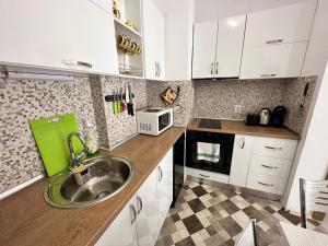 eine Küche mit einer Spüle und einer Mikrowelle in der Unterkunft Luxury apartments in St. John Park in Bansko