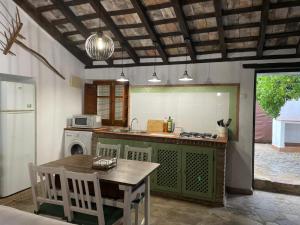 cocina con mesa y fogones horno superior en La casa vieja de Marchenilla, en Jimena de la Frontera