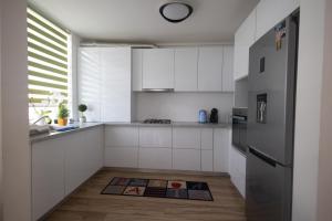 a kitchen with white cabinets and a stainless steel refrigerator at Panorama Luxury Apartment in Oradea