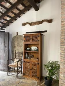 un armario de madera en una habitación con silla en La casa vieja de Marchenilla, en Jimena de la Frontera