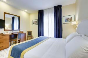 a hotel room with a large bed and a desk at Best Western Hotel La Solara in Sorrento