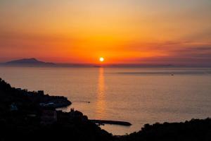a sunset over the ocean with the sun in the sky at Best Western Hotel La Solara in Sorrento