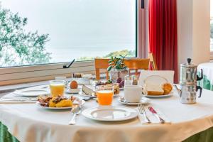 a table with breakfast foods and orange juice on it at Best Western Hotel La Solara in Sorrento