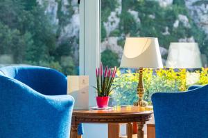 a table with a lamp and two chairs and a window at Best Western Hotel La Solara in Sorrento