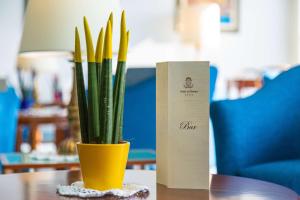 a yellow vase with a plant in it on a table at Best Western Hotel La Solara in Sorrento