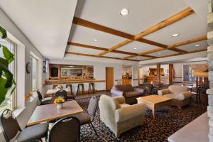 Rodeway Inn & Suites Tomahawk في توماهوك: لوبي فيه كراسي وطاولات وبار
