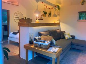 a living room with a couch and a table at The Little Barn in Hoxne