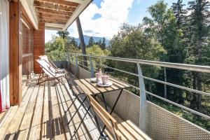 a balcony with two chairs and a table on it at Au Bon Air - Appt au pied des pistes in Chamrousse +4 photos