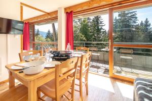 a dining room with a table and a large window at Au Bon Air - Appt au pied des pistes in Chamrousse