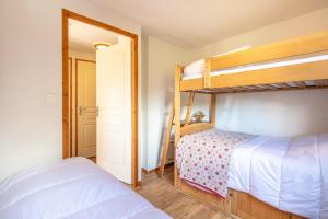 a bedroom with two bunk beds and a doorway at Au Bon Air - Appt au pied des pistes in Chamrousse