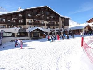 a group of people in the snow in front of a ski lodge at Appartement Confort 1 chambre, ski aux pieds, balcon, Wi-Fi, parking - FR-1-178-171 in Les Bruyères +6 photos