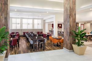 a restaurant with wooden floors and tables and chairs at Hilton Garden Inn Miami Airport West in Miami