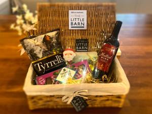 a basket with a bottle of wine and other goodies at The Little Barn in Hoxne
