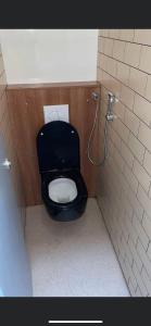 a bathroom with a black toilet in a stall at The Liverpool Pod Travel Hostel in Liverpool