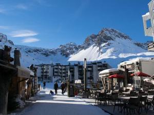 a street with tables and chairs in front of a mountain at Appartement Tignes, 3 pièces, 6 personnes - FR-1-480-22 in Tignes