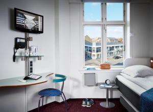 um quarto com uma cama, uma secretária e uma janela em Cabinn Esbjerg em Esbjerg