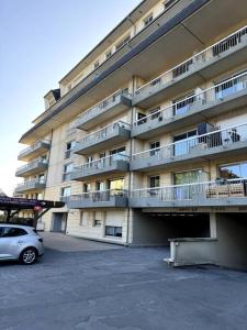 a car parked in front of a large building at Appartement neuf avec balcon et parking privé in Caen