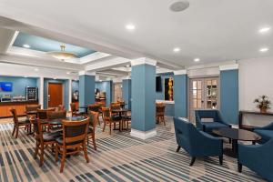 a dining room with tables and chairs and blue walls at Comfort Suites Vero Beach I-95 in Vero Beach