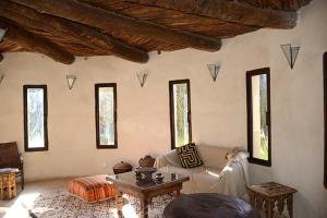 a living room with a couch and a table at DAR SOKASA Riad authentique et contemporain in Aït Skouala