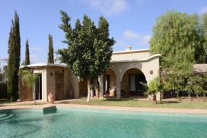 una casa con piscina frente a ella en DAR SOKASA Riad authentique et contemporain, 