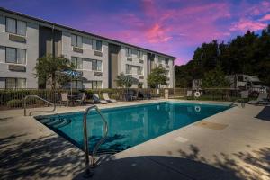 a swimming pool in front of a apartment building at Sleep Inn in Wilmington