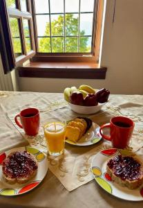 a table with plates of breakfast foods and cups of coffee at Vradeto Guesthouse in Vradéton