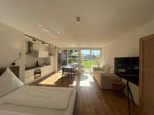 a room with a bed and a kitchen and a living room at Urban Lodges - Studio Apartments am Seerhein in Konstanz