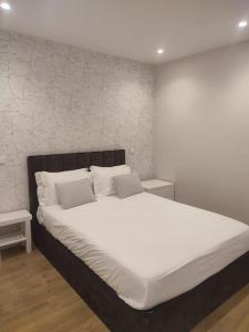 una camera da letto con un grande letto bianco con due cuscini di Braga Center Apartments - São Vicente 78 a Braga
