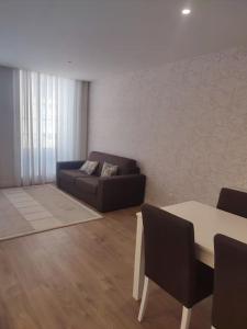 un soggiorno con divano e tavolo di Braga Center Apartments - São Vicente 78 a Braga