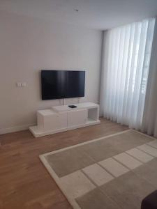 a living room with a flat screen tv on a white cabinet at Braga Center Apartments - São Vicente 78 in Braga