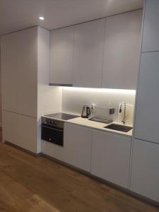 a white kitchen with a sink and a stove at Braga Center Apartments - São Vicente 78 in Braga