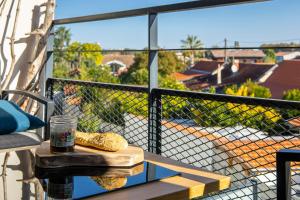 a table on a balcony with a view of a roof at Le Cèdre du Bassin - Au cœur de la Teste in La Teste-de-Buch