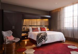 a bedroom with a large bed and a red rug at QT Sydney in Sydney