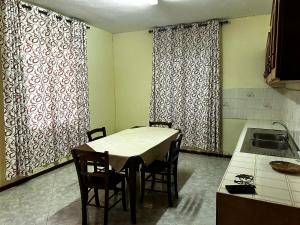 una cucina con tavolo, sedie e lavandino di Villa by V a Grande Gaube