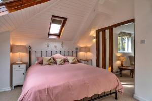 a bedroom with a large bed with pink sheets at Finest Retreats - Heath Hills in Okehampton