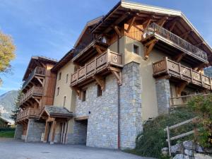 a large building with wooden balconies on top of it at Duplex Charmant Près des Pistes avec Hammam et Cheminée à Courchevel Le Praz - FR-1-568-8 in Courchevel