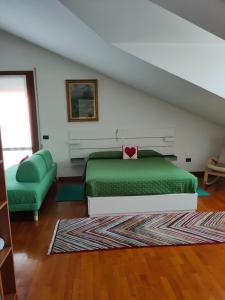 ein Schlafzimmer mit einem grünen Bett und einem Sofa in der Unterkunft A casa di Rosa in Padua