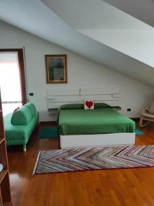 a bedroom with a green bed and a couch at A casa di Rosa in Padova