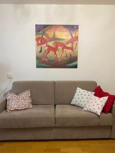 a couch in a living room with a painting on the wall at Appartamento Grunwald in Brunico