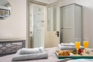 a room with a bed with two glasses of orange juice at The Bolt Hole, Winchcombe, Charming Dog-Friendly Cottage in Winchcombe