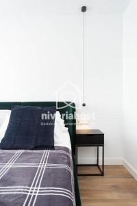 um quarto com uma cama e uma mesa de cabeceira ao lado de uma cama em The Luxe Santa Cruz, by Nivariahost em Santa Cruz de Tenerife