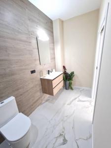 a white bathroom with a toilet and a sink at Exclusivo y único apartamento in Valencia