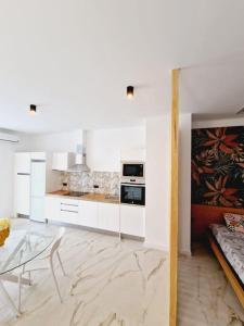 a kitchen with white cabinets and a glass table at Exclusivo y único apartamento in Valencia