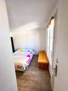 niewielka sypialnia z łóżkiem i drewnianym stołem w obiekcie Charming two-room apartment near Montparnasse w Paryżu