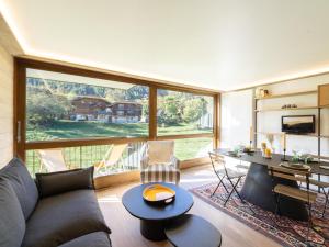 a living room with a couch and a table at Appartement familial rénové, au cœur de Courchevel Le Praz, proche des pistes et commodités - FR-1-568-30 in Courchevel +6 photos